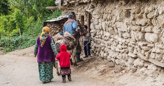 Family with a donkey at their home in the mountain village of Margib, Sughd Province, Tajikistan.